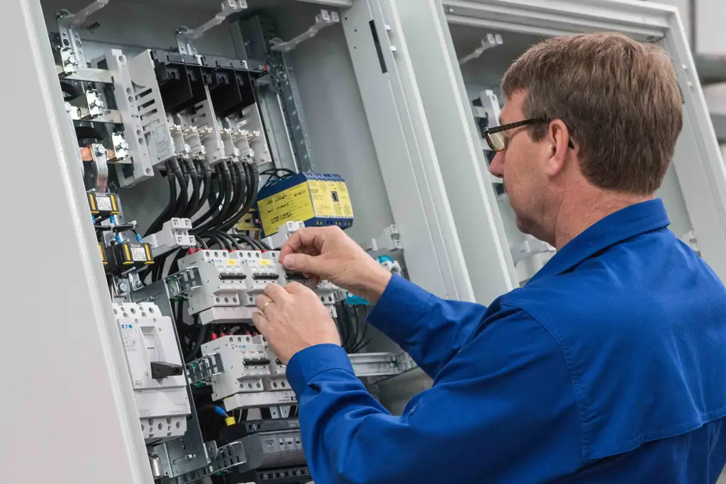 Electrician wiring breakers in an open distribution panel